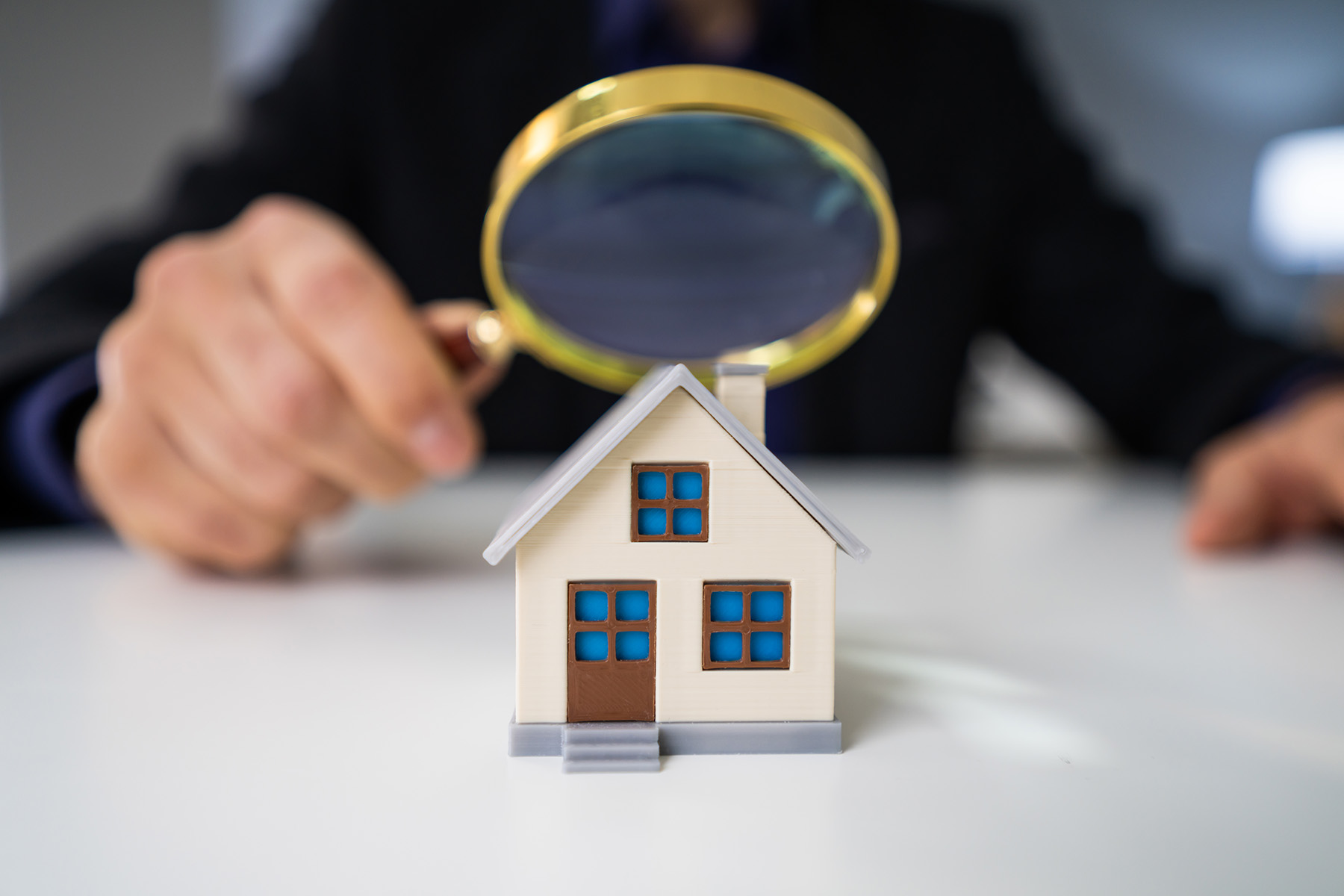 Close-up Of A House Model Seen Through Magnifying Glass On Table